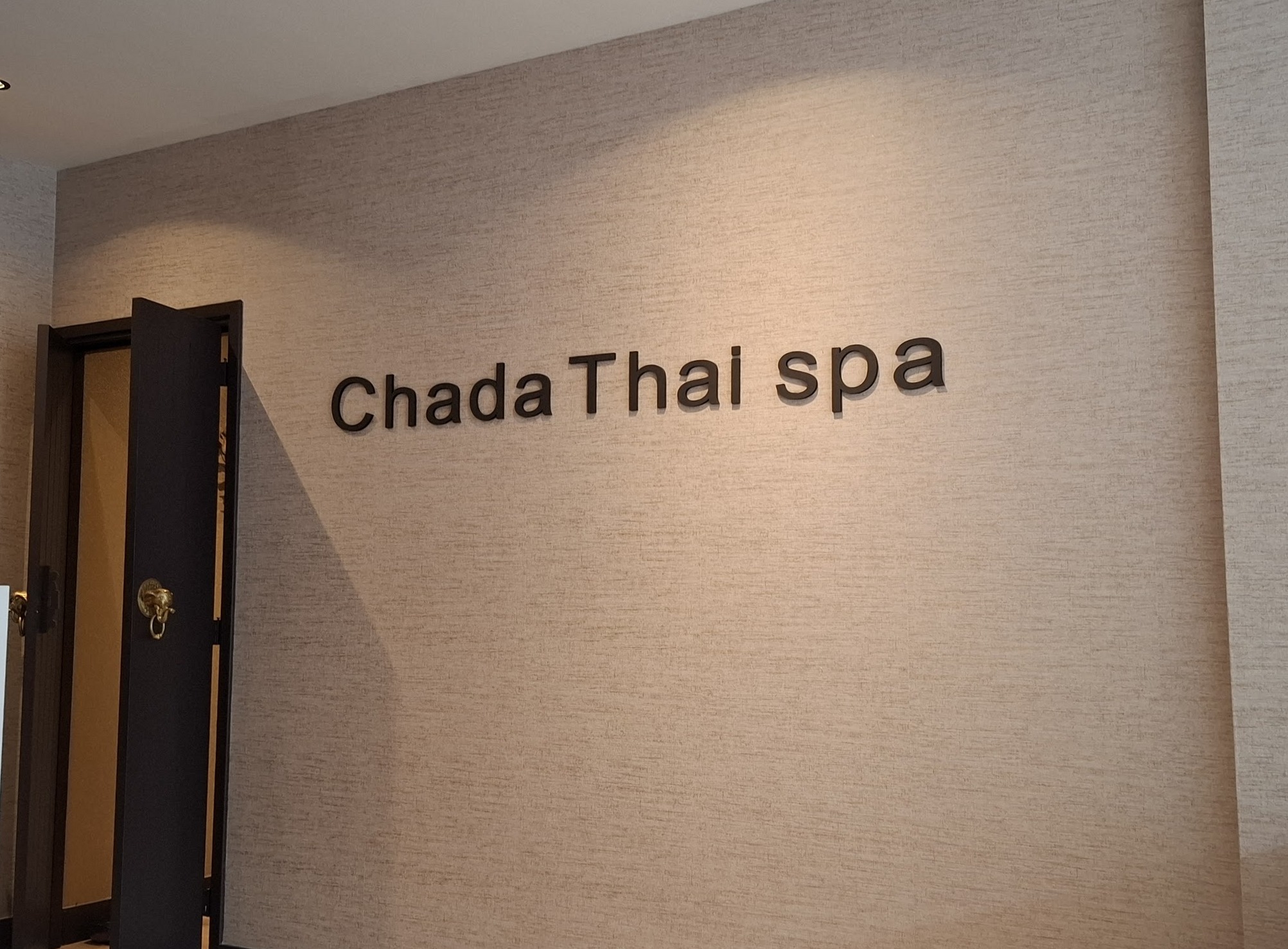 Het Chada Thai spa woordmerk op de muur in de salon